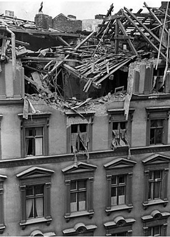 Damaged roof of a building on Mariannenstraße in Berlin following the RAF raid of 28th/29th August. A state funeral for the victims of the raid was was held, with many Nazi functionaries in attendance, for maximum propaganda effect. (Multi-storey residential building, its roof severely damaged, with rafters smashed and the rooms below exposed)
