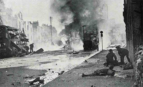 Carnage in Broad Wier, Bristol, following the attack on 28th August.
📷 ww2today.com

(Scene of devastation on a city street, with a bus badly damaged by blast and two more on fire. Two men are bending over a body on the pavement)