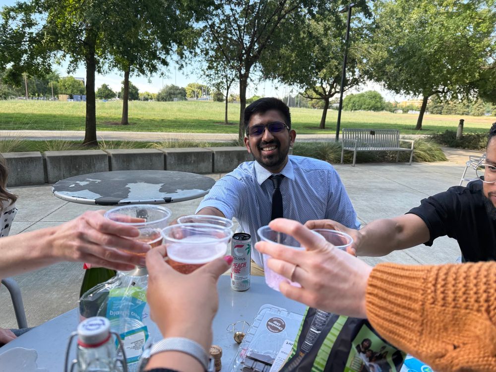 A PhD student successfully defended his qualifying exam at UC Davis and doing cheers with his mentors and peers.