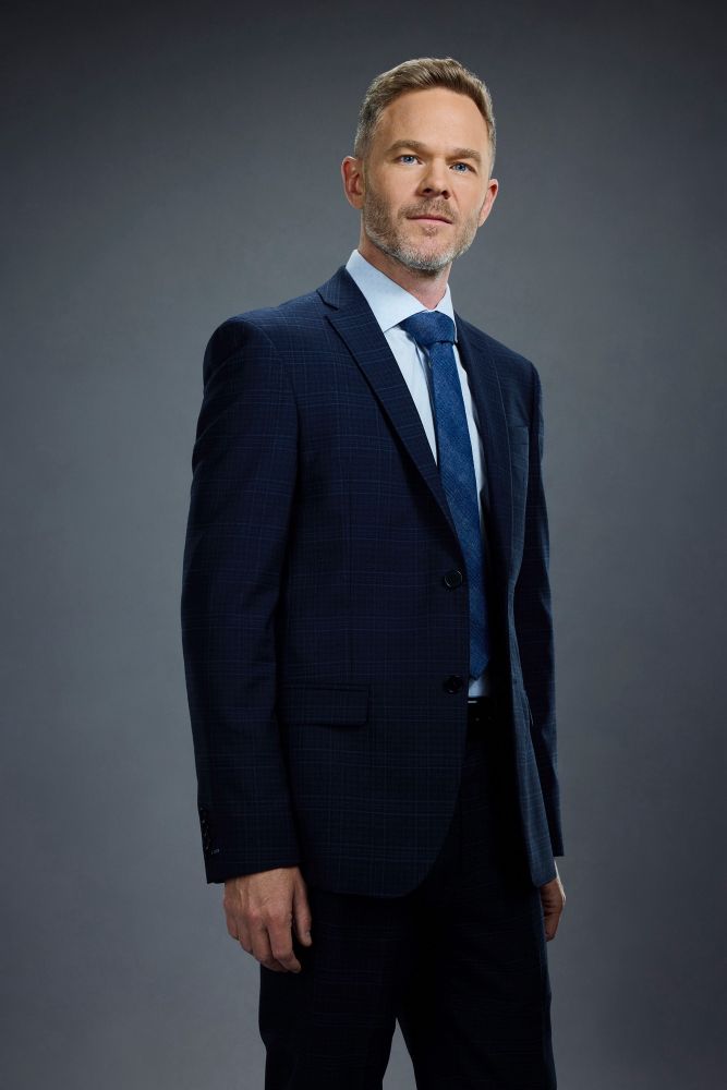 the rookie character, wesley ever, in blue suit with a white button up and blue tie. 