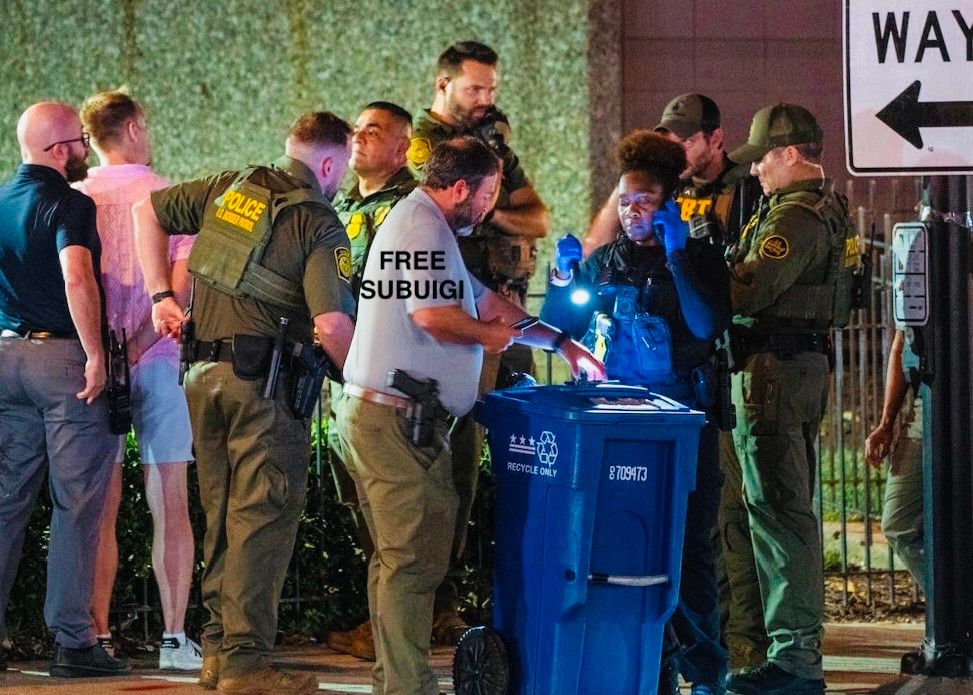 A salmon shirted grey shorted citizen (Subuigi Rangeone) is pictured hemmed up by nine federal officers after experiencing what appeared to have been an epileptic seizure while holding a Subway $57 footlong. Calls to #FreeSubuigi have begun. 