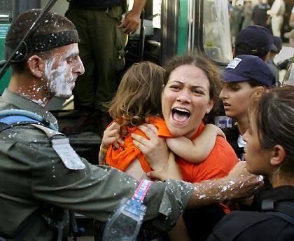 Israelische Familien werden von IDF-Soldaten und Polizei in Busse gedrängt, ein Soldat ist mit Schaum beschmiert