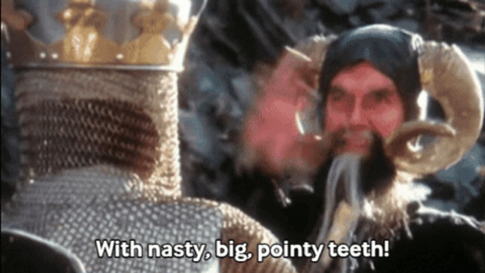 a man with horns is talking to another man with a beard and says with nasty big pointy teeth