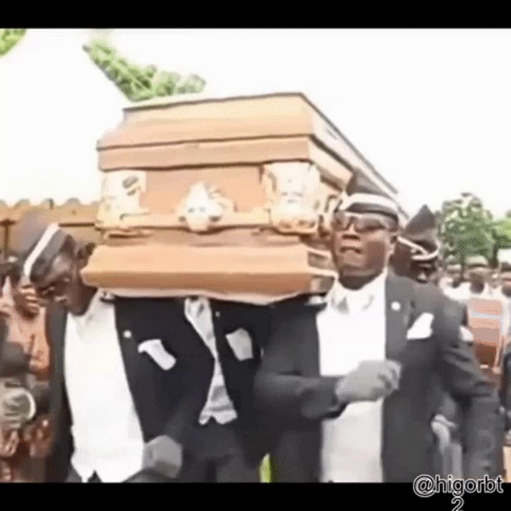 a group of men in tuxedos are carrying a coffin and dancing .