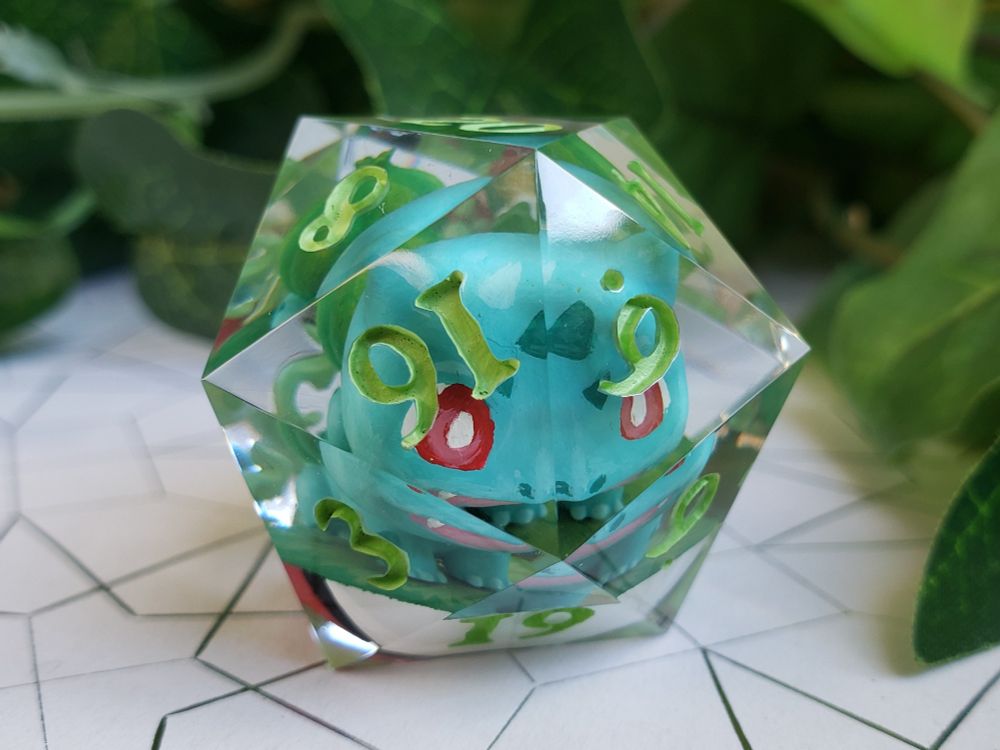 picture of a jumbo D20 with a miniature bulbasaur inside