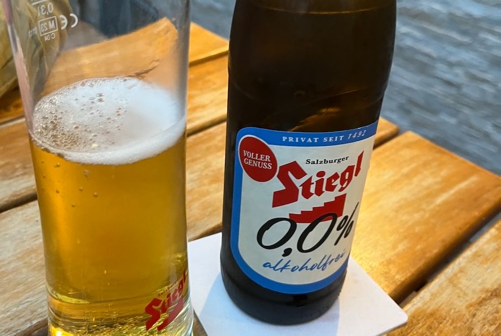 A bottle of Stiegl 0,0% beer. A glass half full of said beer.