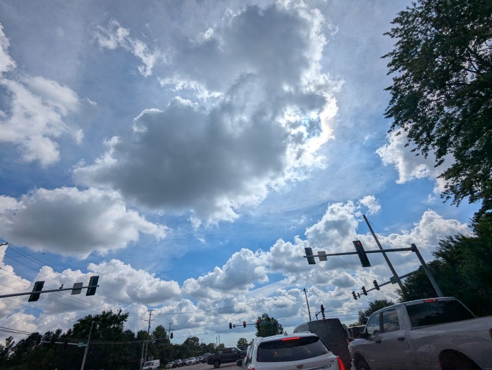 Wide shot of clouds over a suburban road.