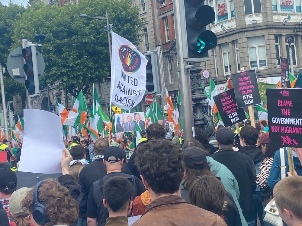 On Dublin’s O’Connell street a group of anti-racist counter protesters face off against an anti-immigrant protest. In the centre, some anti-immigrants hold up a poster with Putin, McGregor and Trump side-by-side 🤢 