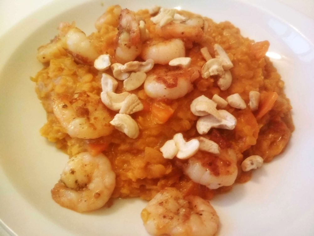 photo d'une assiette contenant un dahl de lentilles corail aux crevettes et noix de cajou