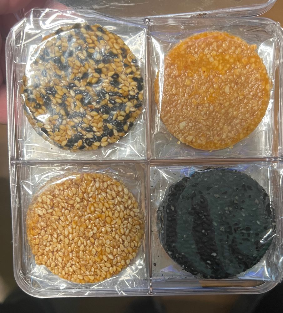 Plastikbox mit vier Fächern mit verschiedenen Talern aus Sesam und Honig