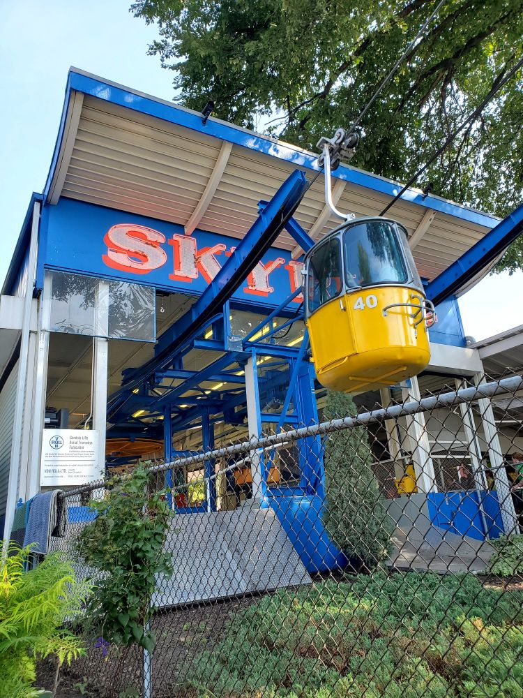 One Skyride station, with a yellow gondola emerging on a cable.