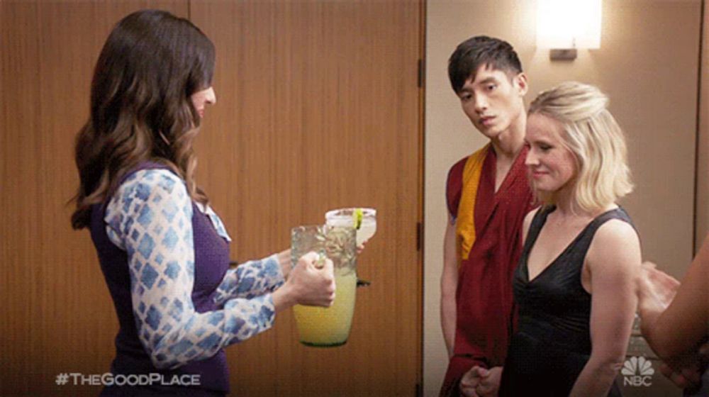 a woman is holding a pitcher of lemonade in front of a man and a woman with #thegoodplace written in the corner