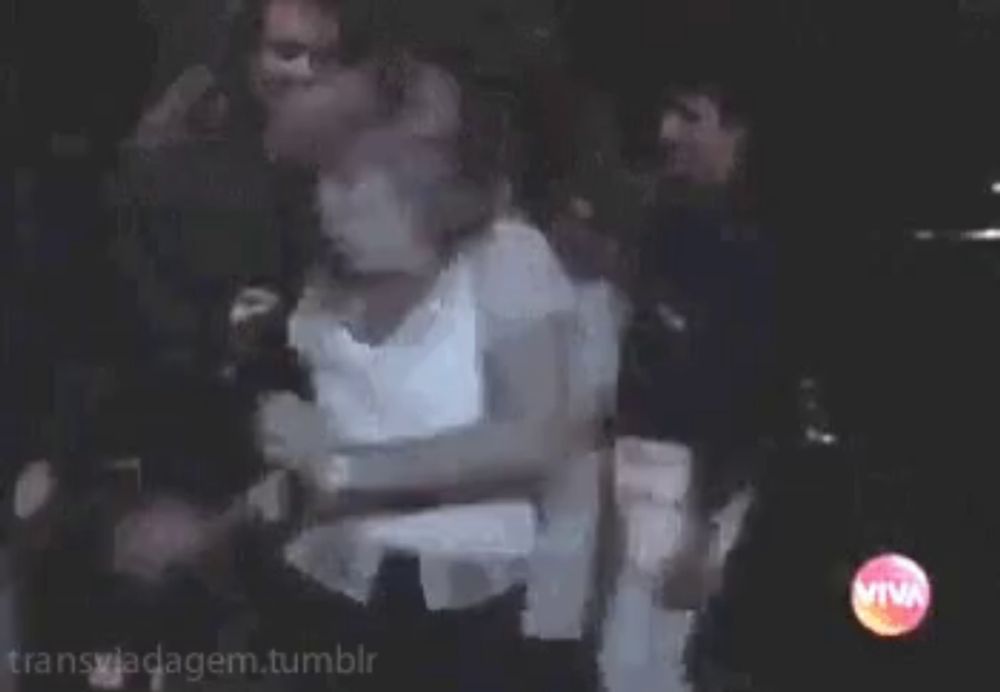 a woman in a white shirt is dancing in a club with a man in a black shirt .