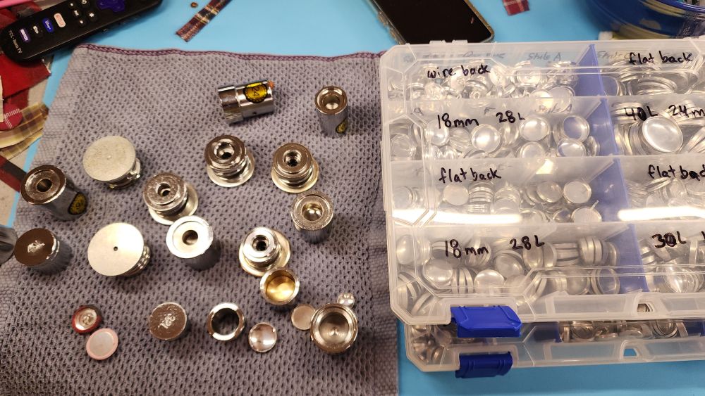 Lots of dies beside a couple tackle boxes of button parts
