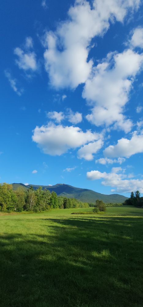 Vertical shot of the sky shows puffy clouds for miles and miles above the mountain