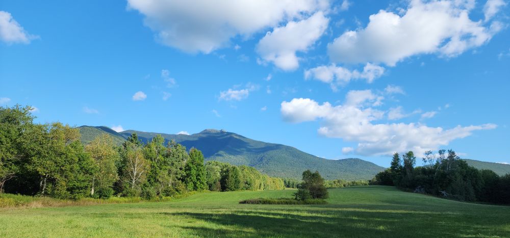 Beautiful blue skies with puffy white clouds over the mountain 