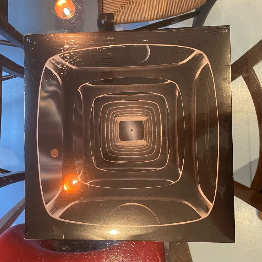 A vinyl LP of Coastal County II by Lomax Productions. The cover image is a series of mirrored structures receding into the distance.