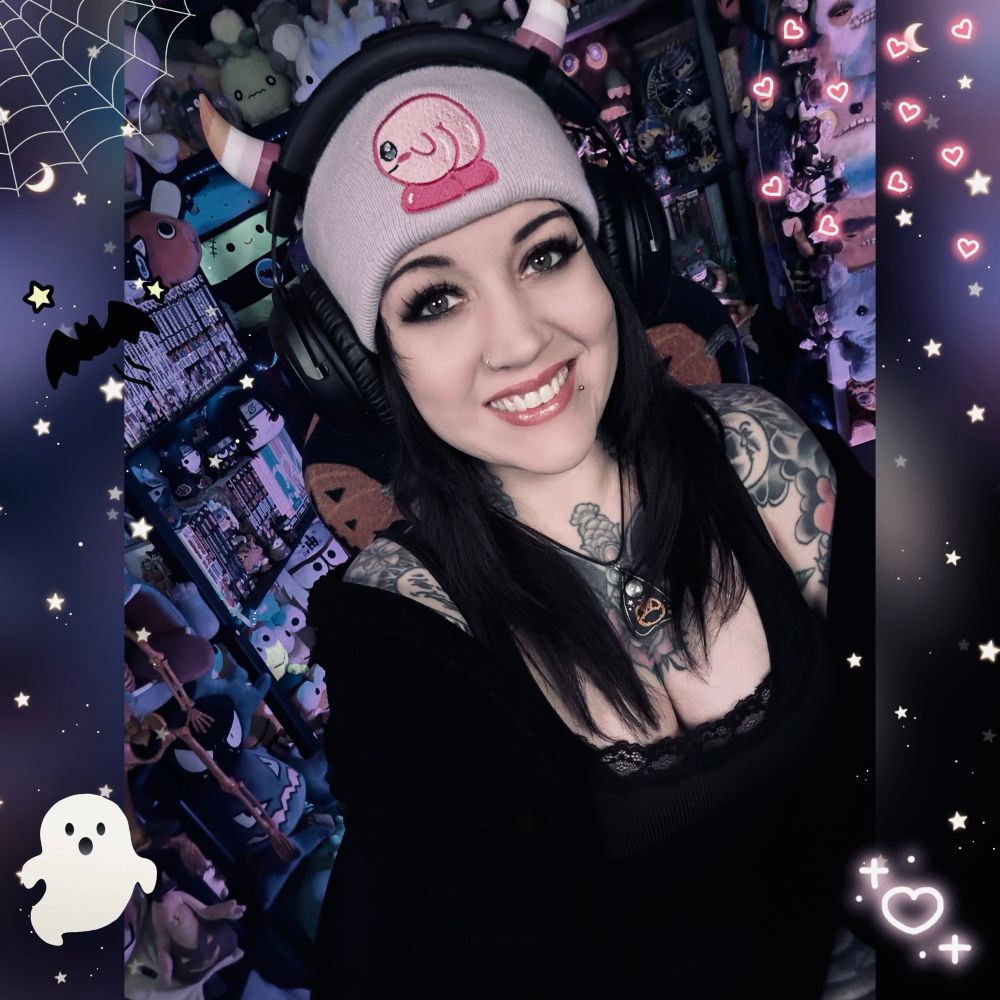 Me in my stream room in a bkack top and a beanie with a cheeked up Kirby in front