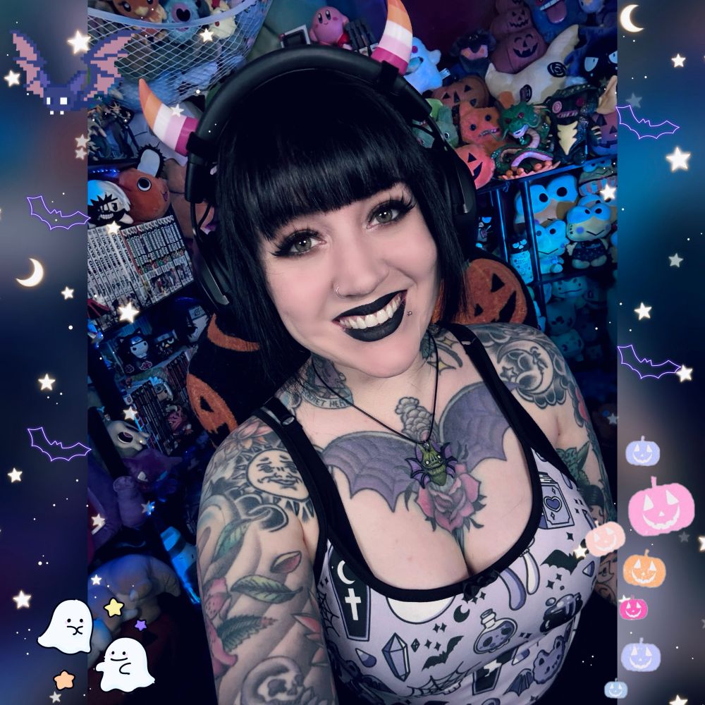 Me in my stream room in a purple top with a Halloween pattern 