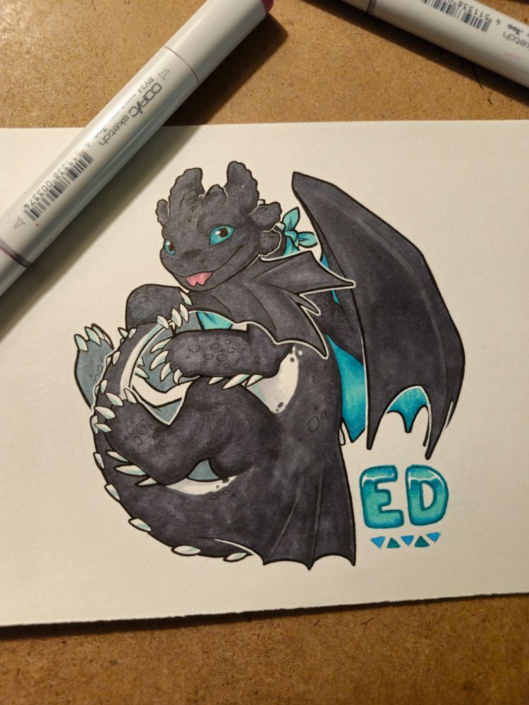 A tuxedo night fury named Ed curls up on the page, holding his tail. He sticks out his tongue playfully at rhe viewer.