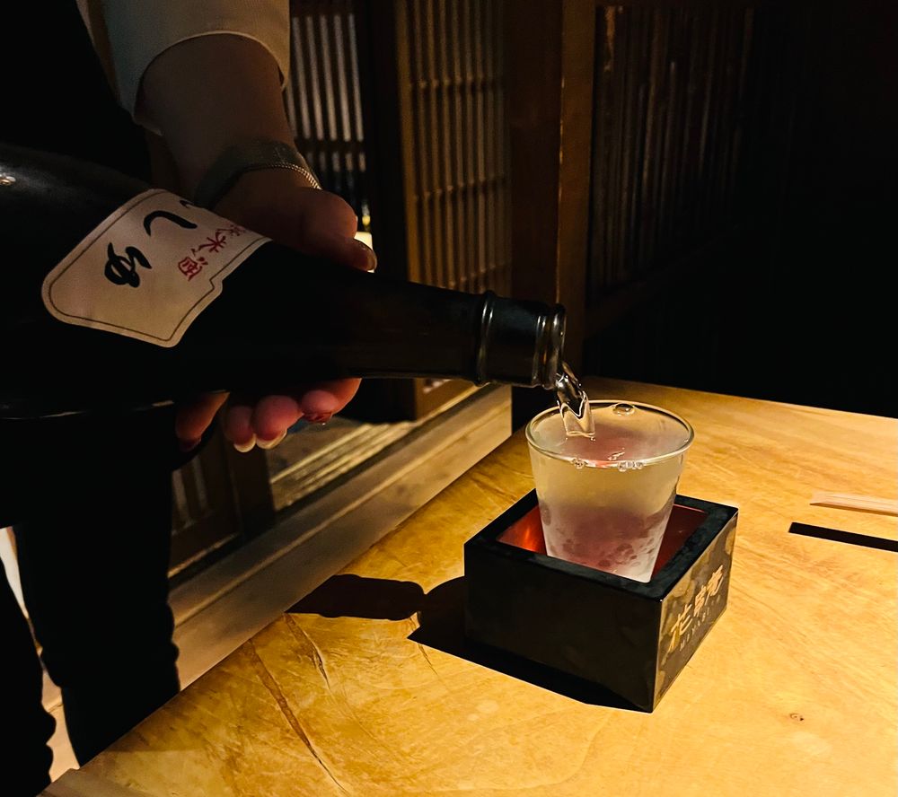 日本酒の田酒をグラスに注いでいる様子