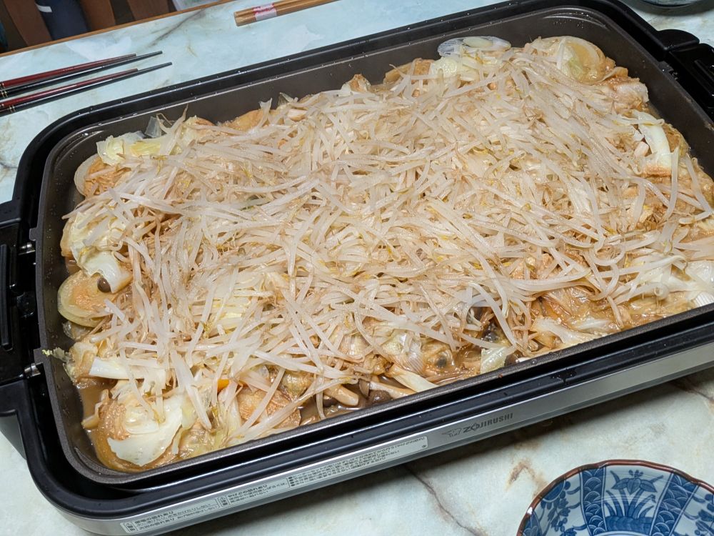 ホットプレートで鮭のちゃんちゃん焼き。最後にもやしで一面を覆ったせいで全体的に薄白い見た目。鮭どこ…。