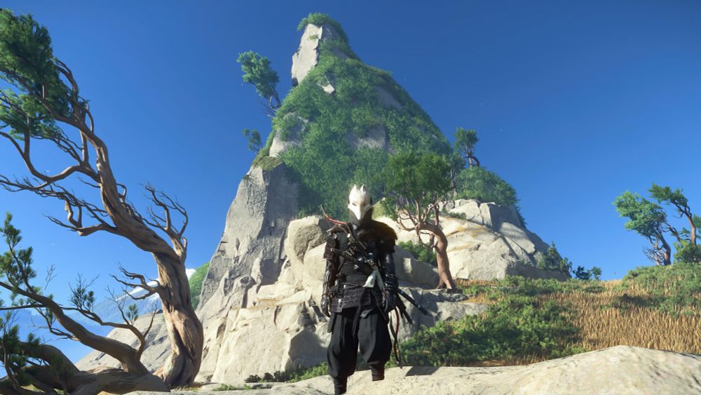 Atsu from Ghost of Yotei standing in front of a small mountain. She has the Kitsune mask on. (White fox mask) 