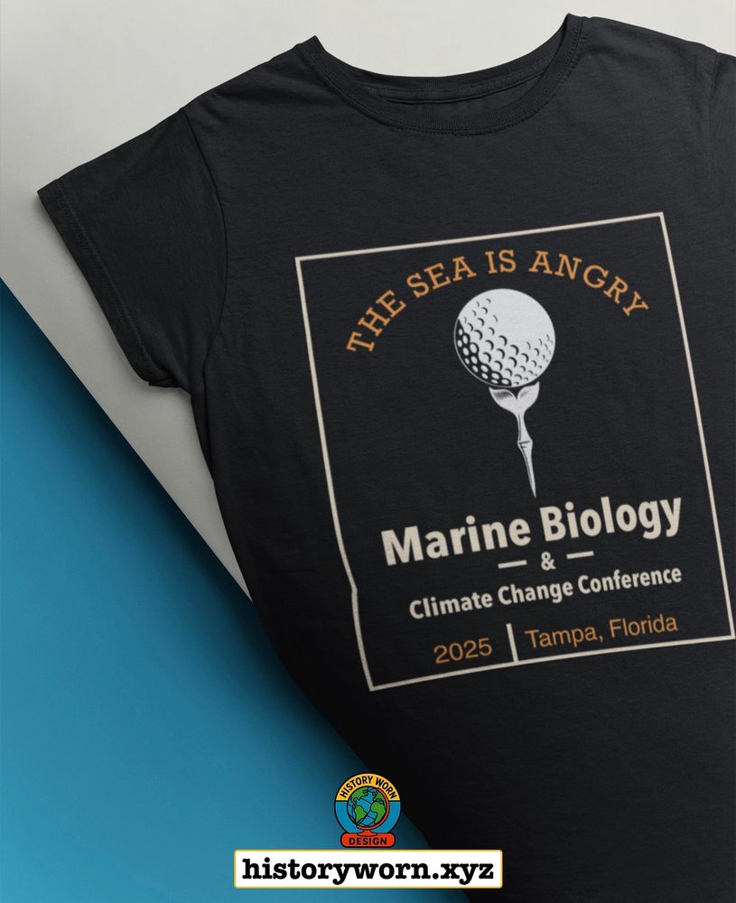 A black t-shirt features a satirical design for a fake “Marine Biology & Climate Change Conference” in Tampa, Florida, 2025. The graphic shows a golf ball lodged in a whale’s spout with the phrase “THE SEA IS ANGRY” above it. The shirt blends scientific parody with dry, ocean-themed humor.