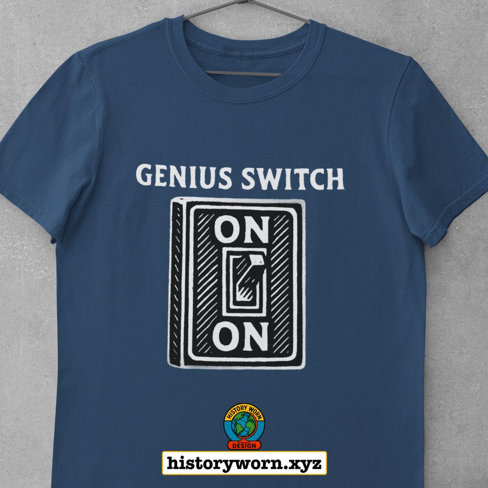 Dark blue t-shirt with a white graphic of a light switch labeled “GENIUS SWITCH.” The switch has the word “ON” written above and below it, indicating it is always on.