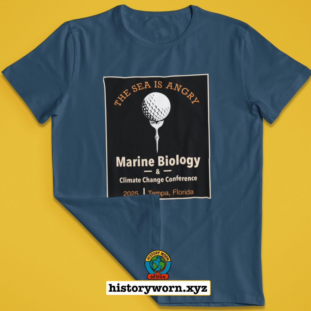 A blue t shirt displays a rectangular graphic with a golf ball on a tee and the text The Sea Is Angry above Marine Biology and Climate Change Conference, 2025, Tampa Florida. A small History Worn Design logo and the site historyworn.xyz appear below.