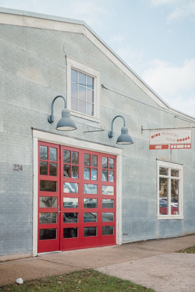 Red garage door on a grey brick barn