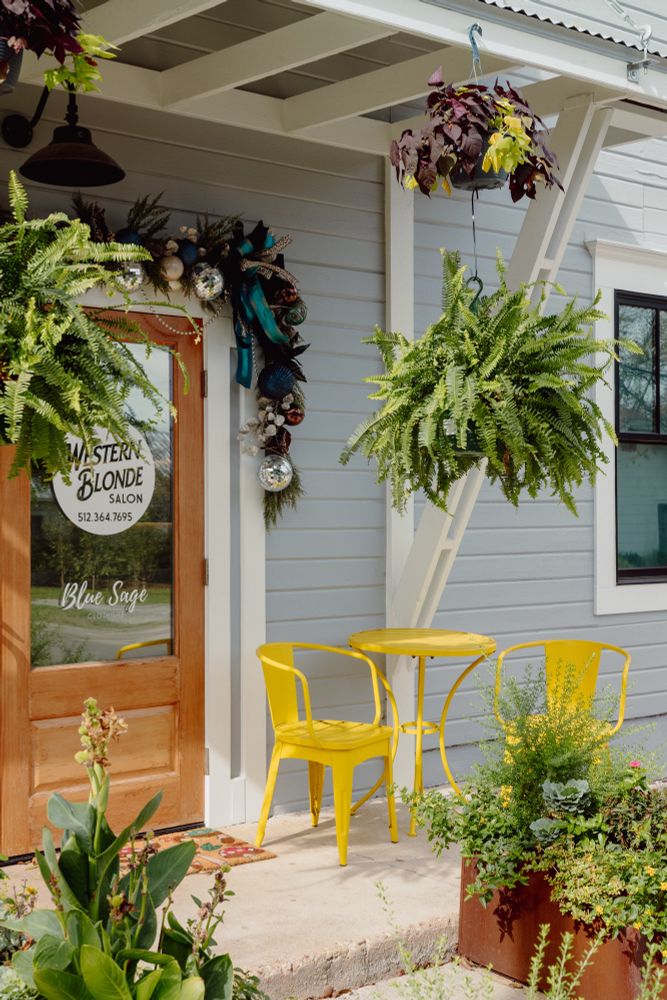 A yellow table and chairs in front of a light blue shop