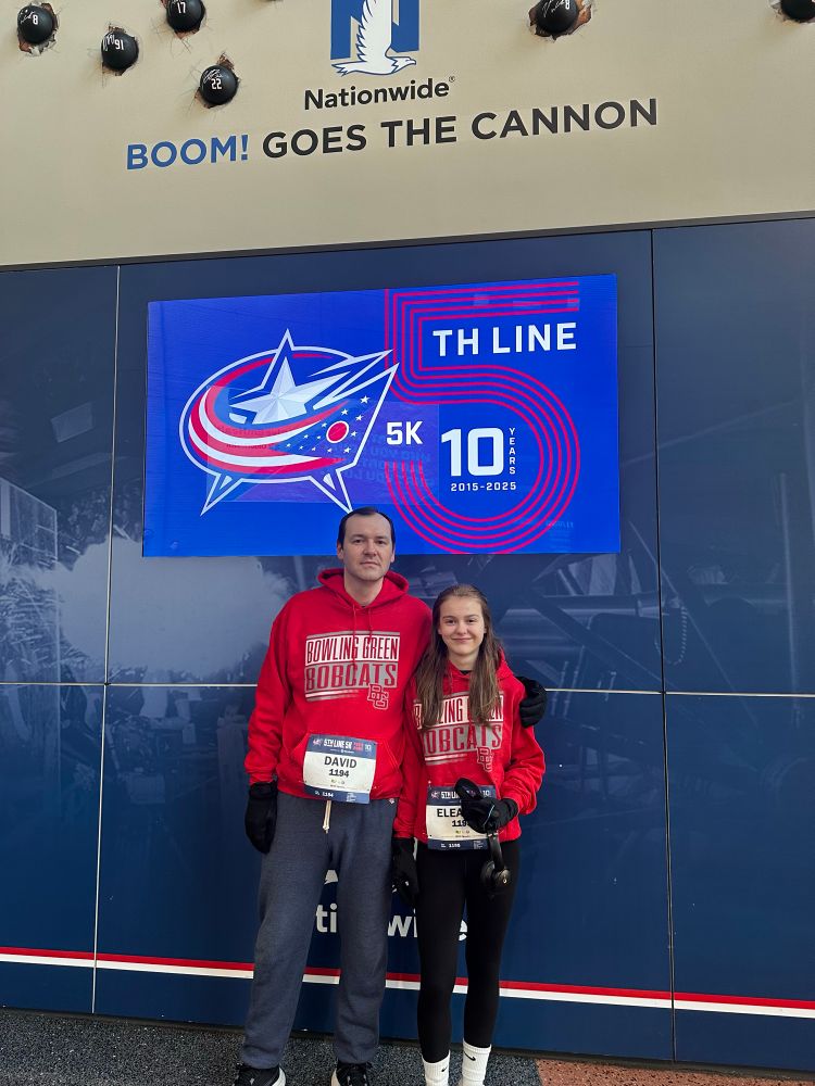 Dad and daughter in red hoodies getting ready to run a 5k