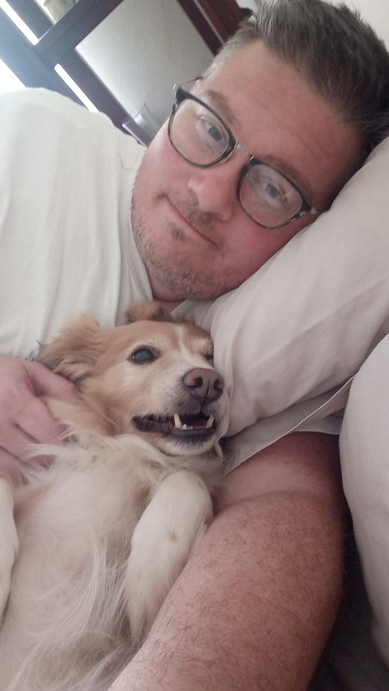 Me, in bed cuddling a very fluffy, happy Milo the Pomeranian x Jack Russell Terrier.