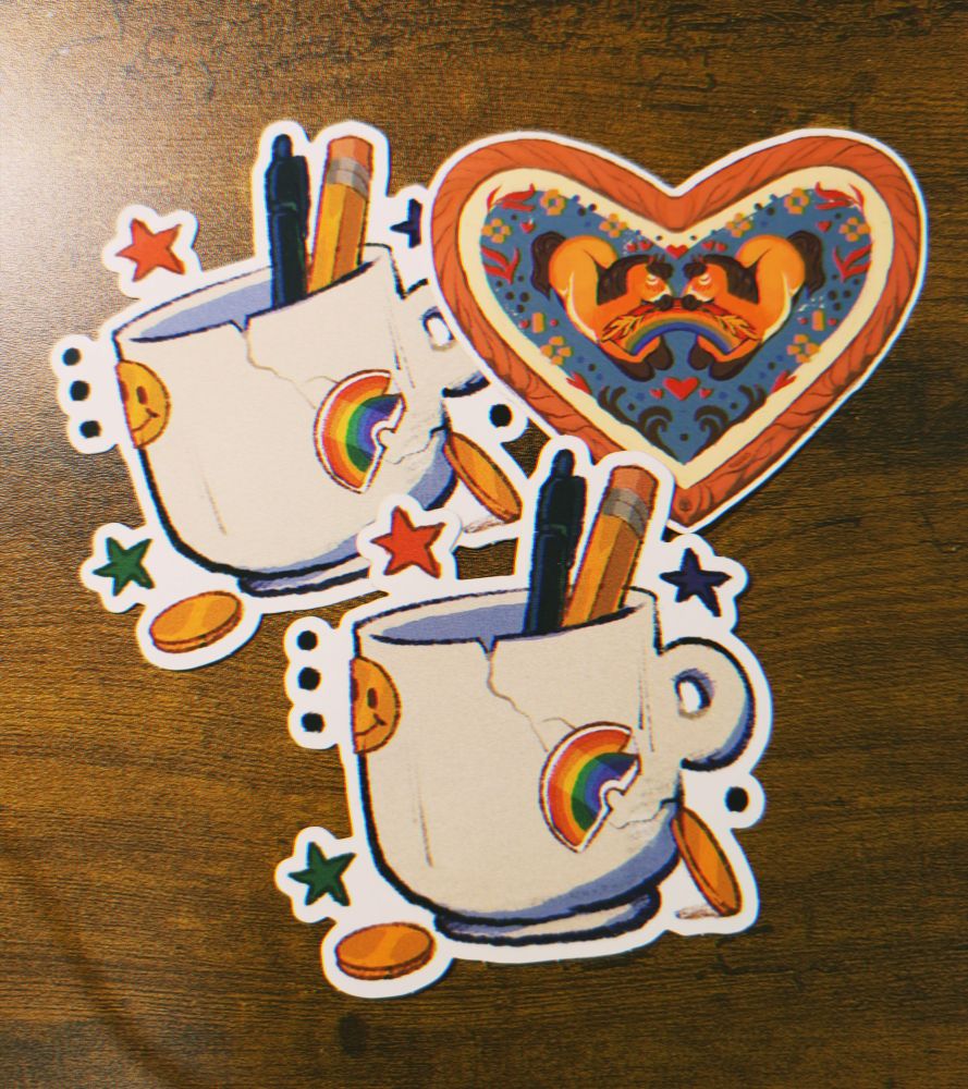 Three stickers designed by Reywolfe. Two of a chipped artist mug and one of two horses sharing a rainbow.
