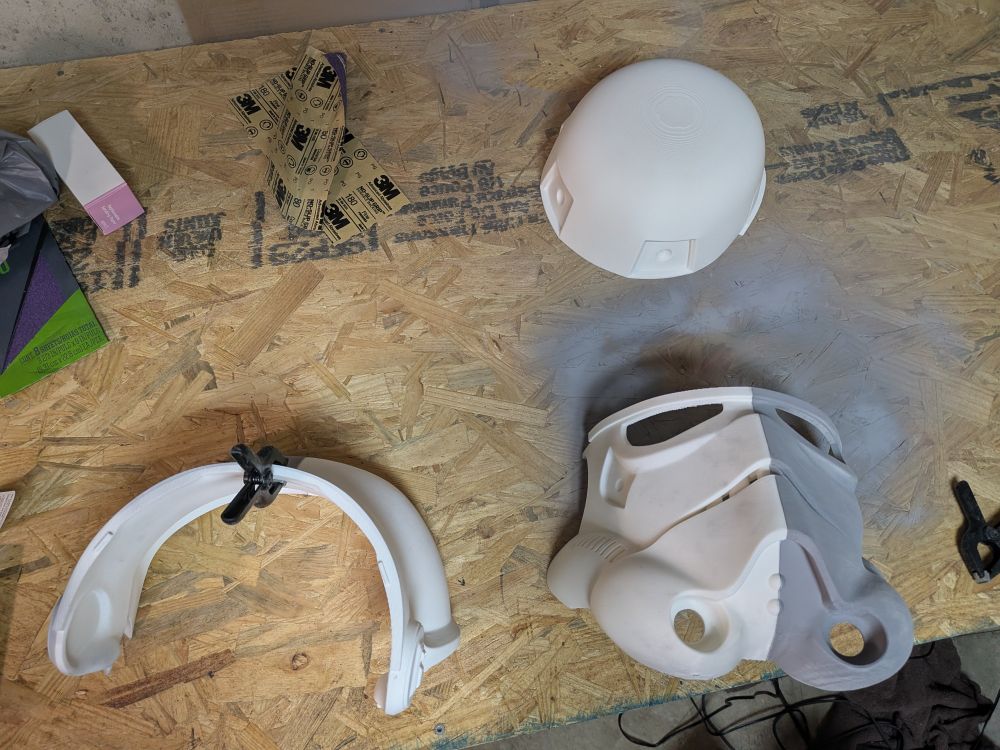 3d printed pieces of a stormtrooper helmet being glued together 