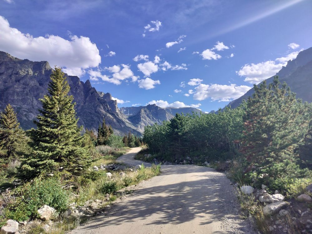 A photo of a mountain valley with sun rays and conifer trees