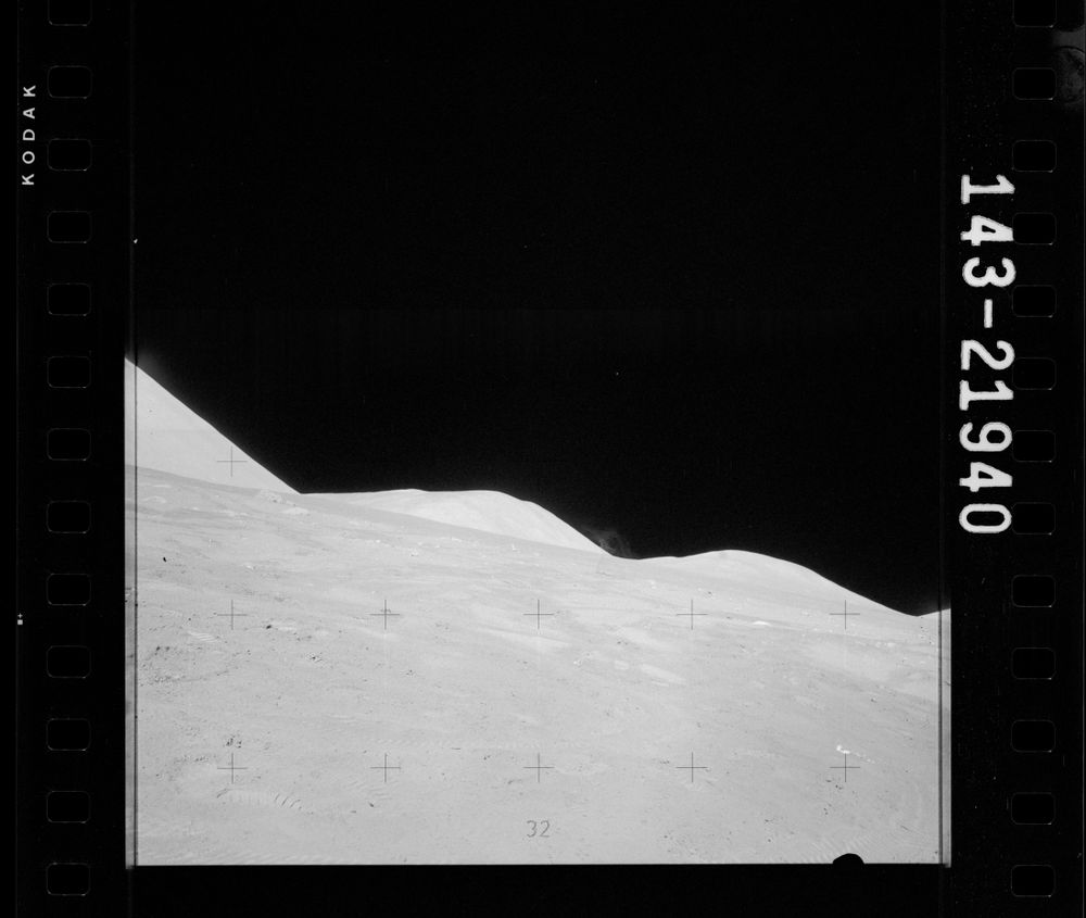 Apollo 17, photo number AS17-143-21940: Continuation of the previous image, except now the object is gone, the camera is slightly tilted, and a distant little plume of dust is visible against the sky.