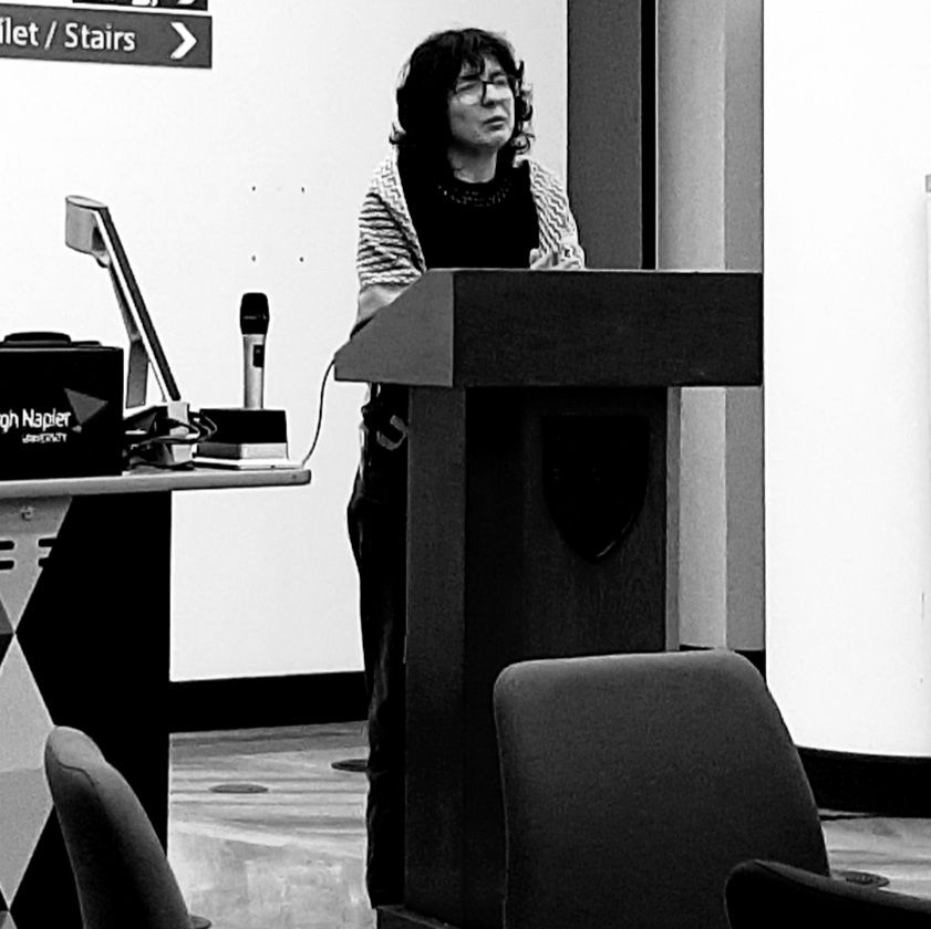 Black and white image of Dr Pali at the lectern. 