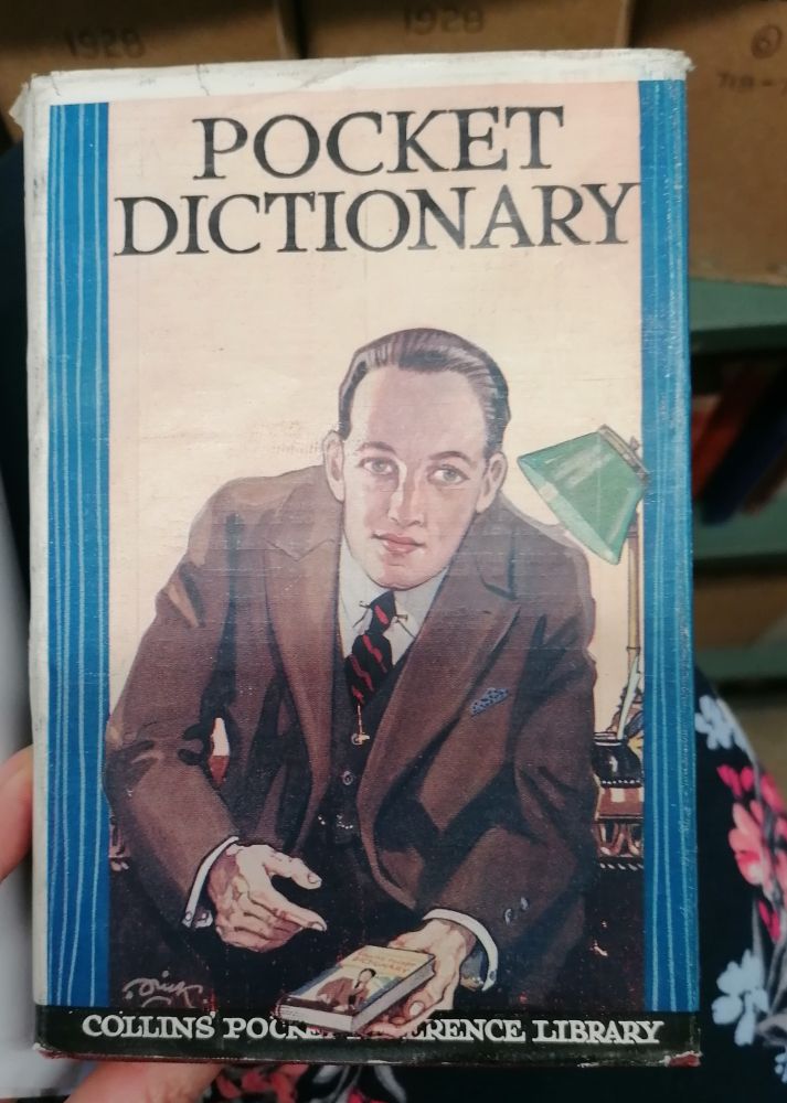 The cover of a 1928 Pocket Dictionary featuring a smartly dressed gentleman. 