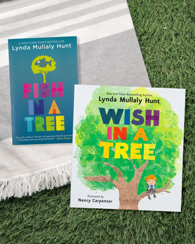 FISH IN A TREE and WISH IN A TREE by Lynda Mullaly Hunt and illustrated by Nancy Carpenter book covers on a blanket and grass backdrop