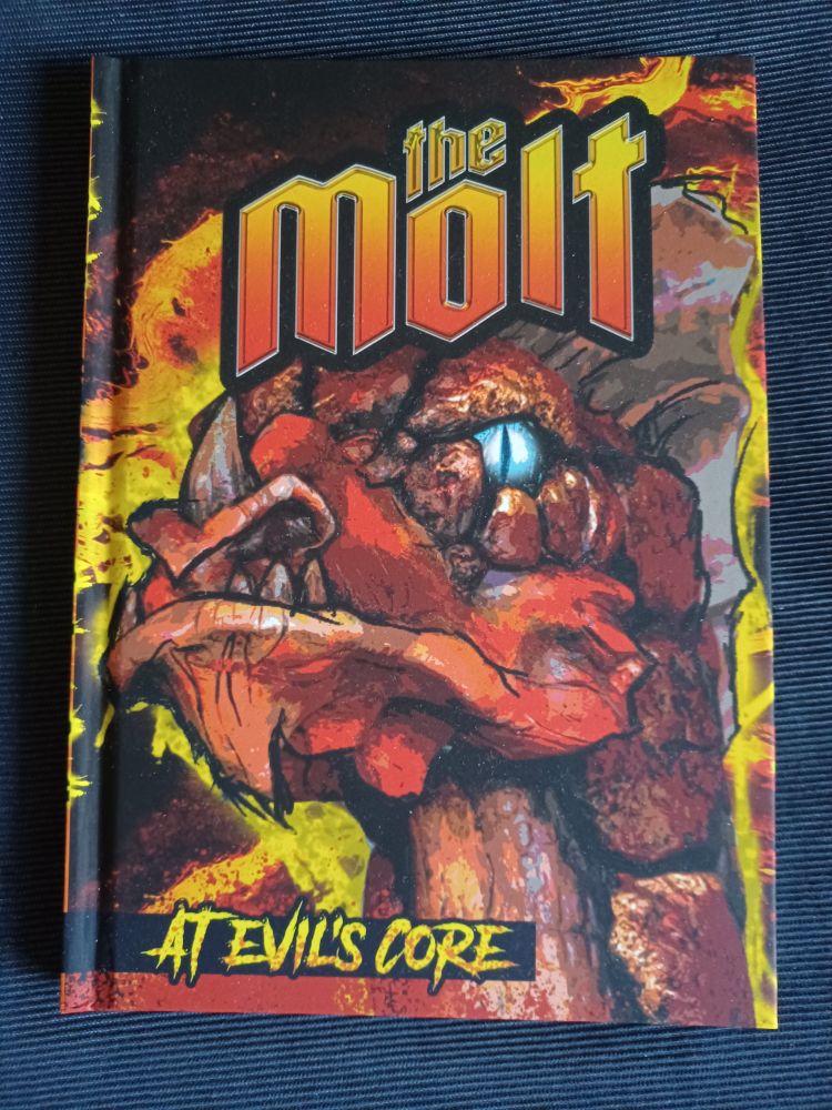 The Molt core rulebook, featuring a red lizard like creature with a glowing blue eye. The cover is ablaze with bright yellow and fiery red colors and at the bottom is the slogan "At the evil's core". 
