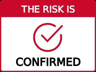 A red and white label with a red checkmark icon in the centre. The text says The Risk Is: Confirmed