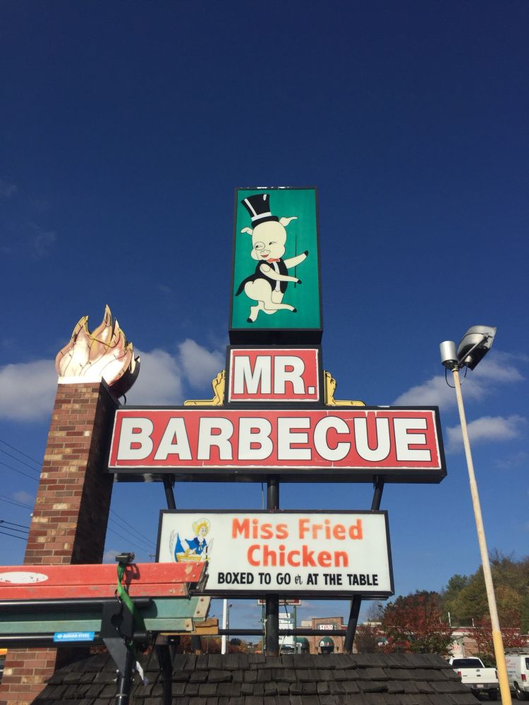 Sign that reads “MR. BARBECUE” with a dancing pig above it. A smaller sign below reads “Miss Fried Chicken.” Photo taken in Winston-Salem, NC.