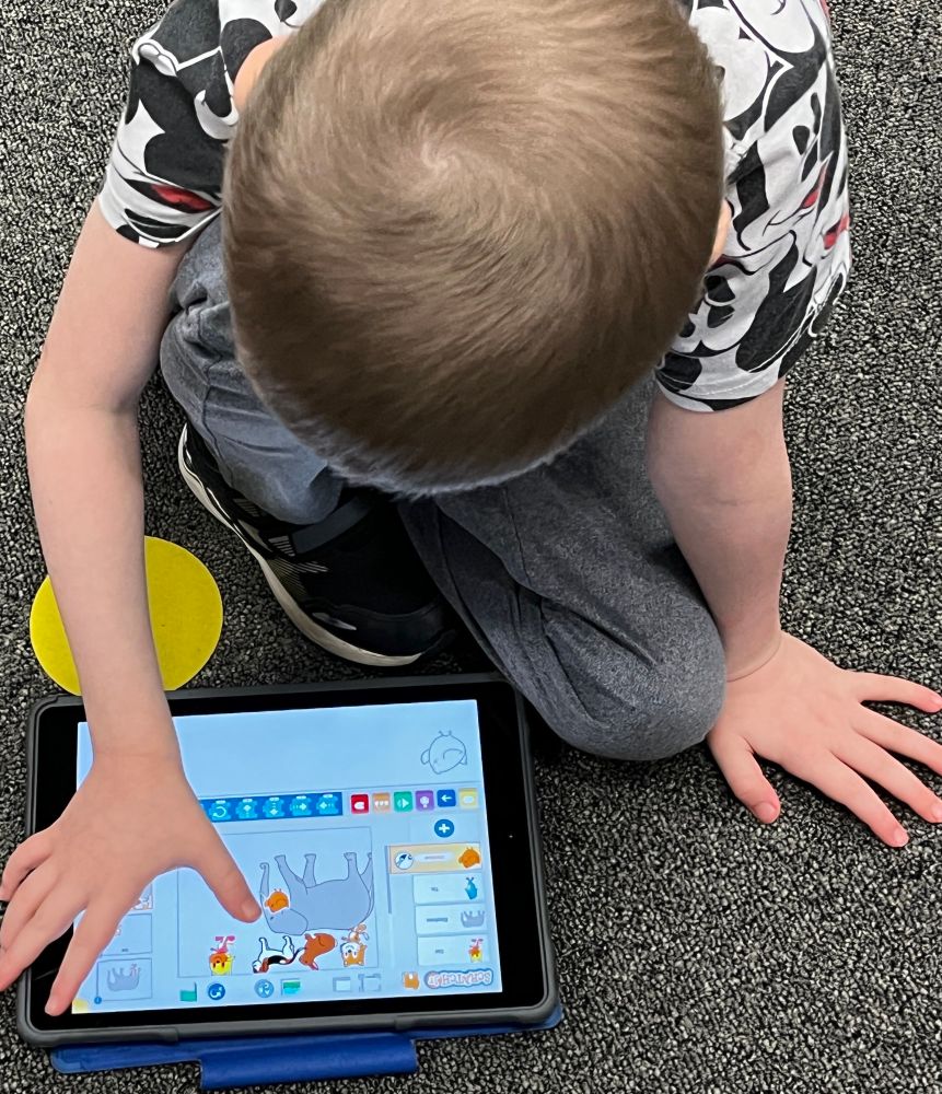 A student works on Scratch Jr on iPad. 