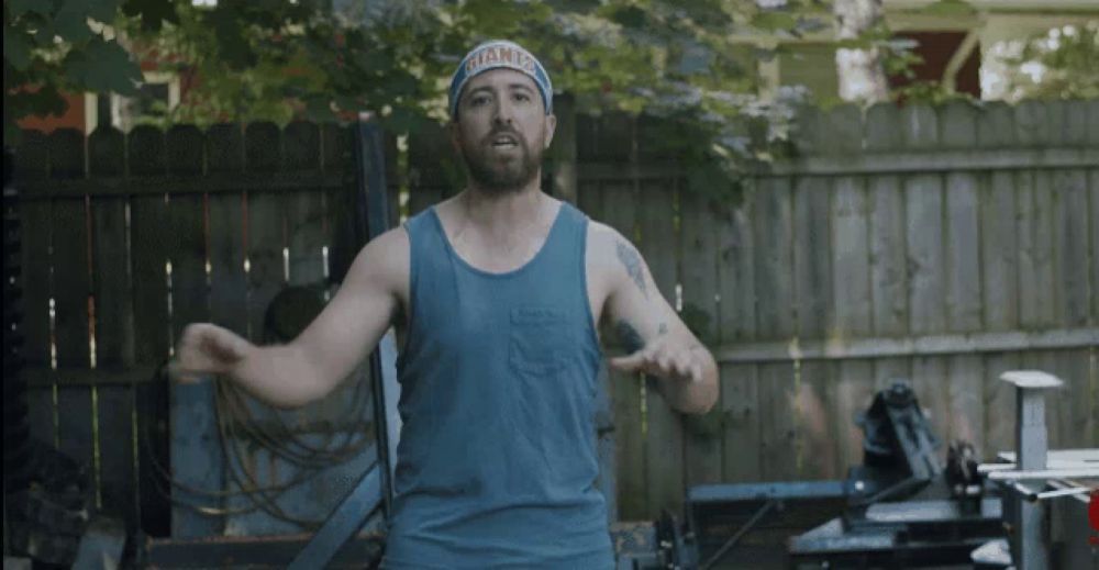 a man wearing a blue tank top with the word lift on the bottom