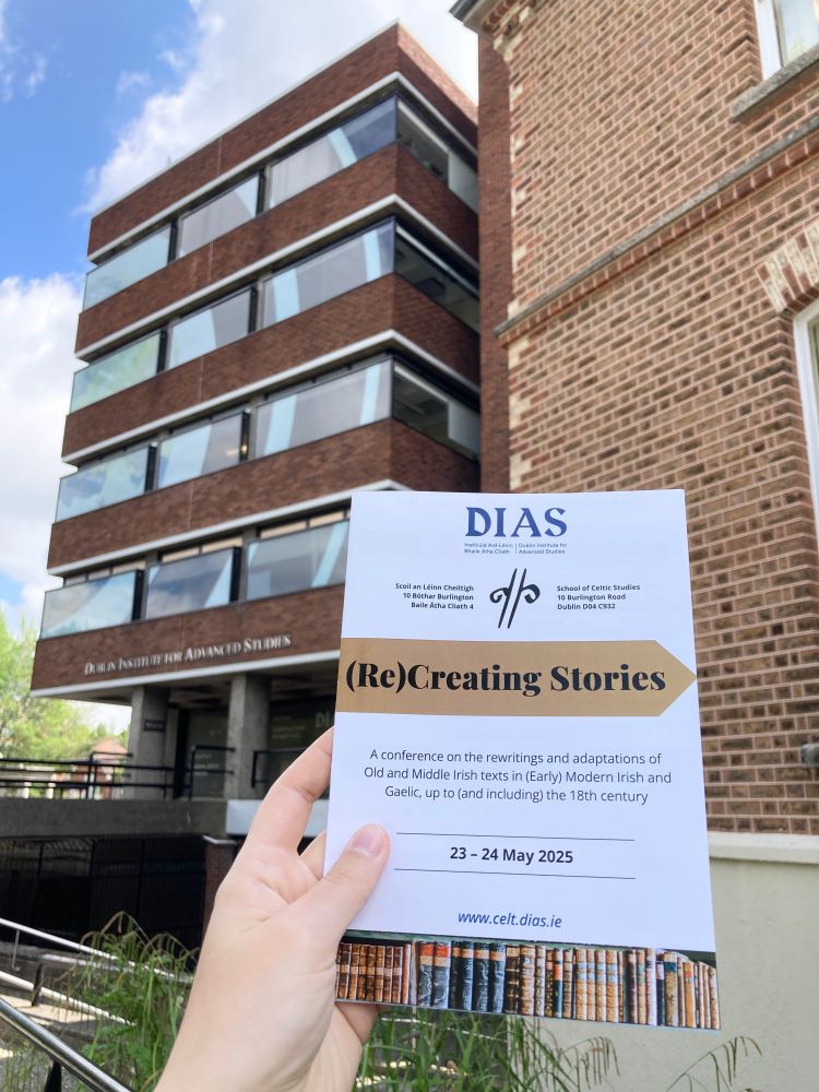 Picture of the programme of the (Re)Creating Stories conference in front of the DIAS building.