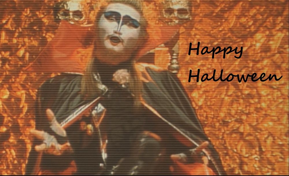 A frame from Godzilla vs Biollante (1989).
A man in a demonic costume is seated on a throne adorned with skulls in front of a metallic orange background. The words "Happy Halloween" have been added in a script font.