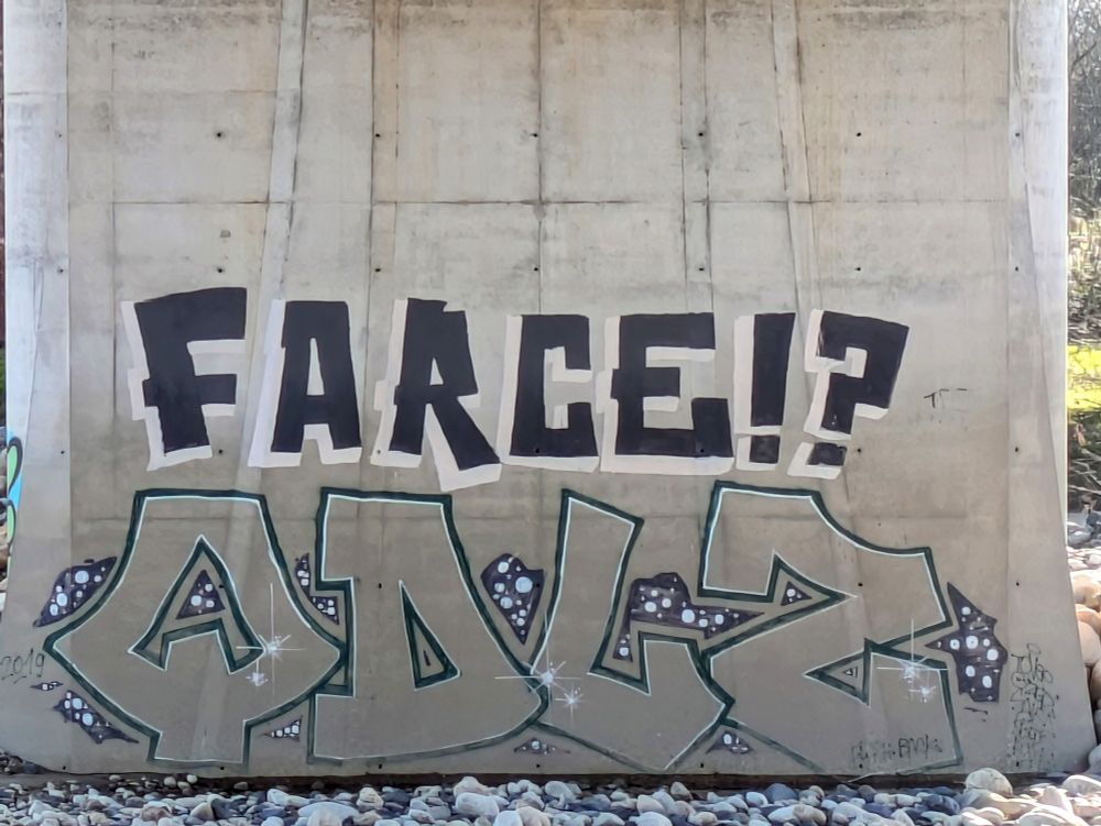 Graffiti avec l'inscription Farce ? en noir sur un pilier de pont zoomé 