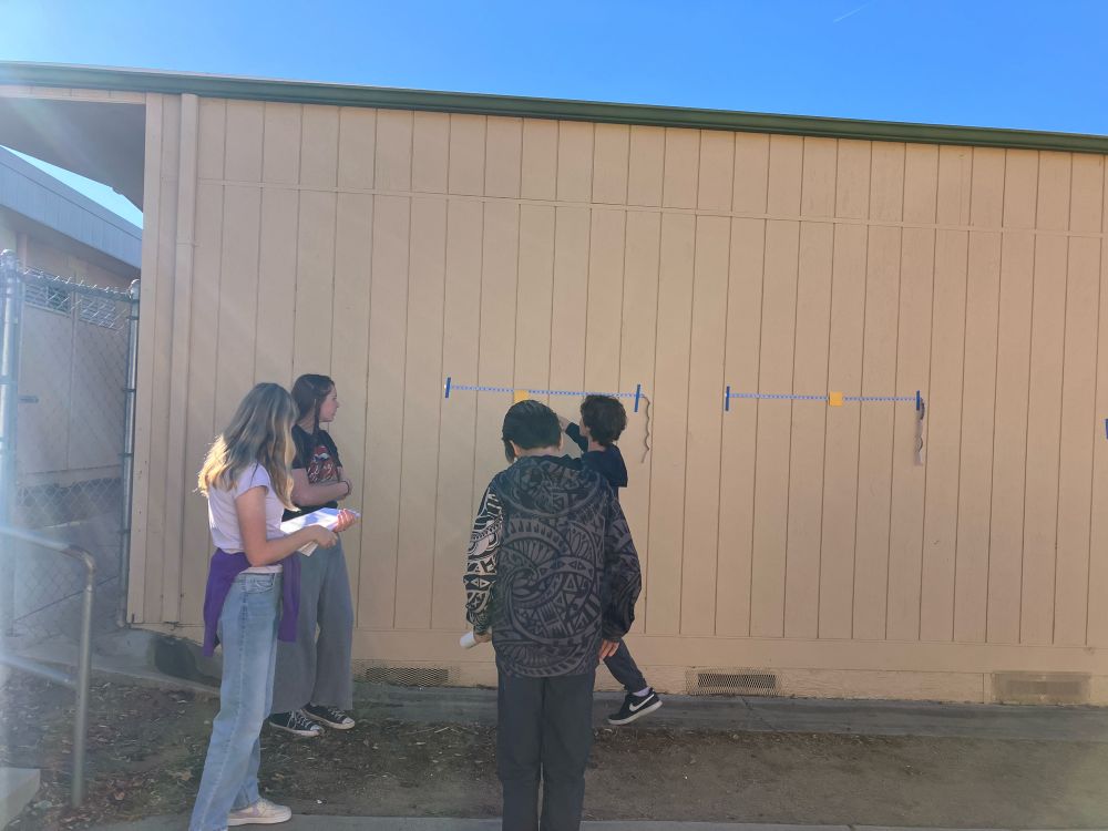 Students outside, looking at a measuring tape to measure field of view